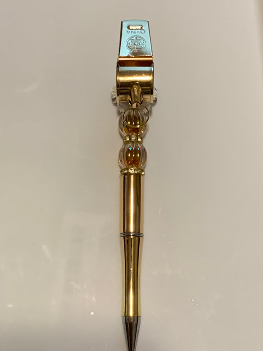 Gold whistle on a gold pen